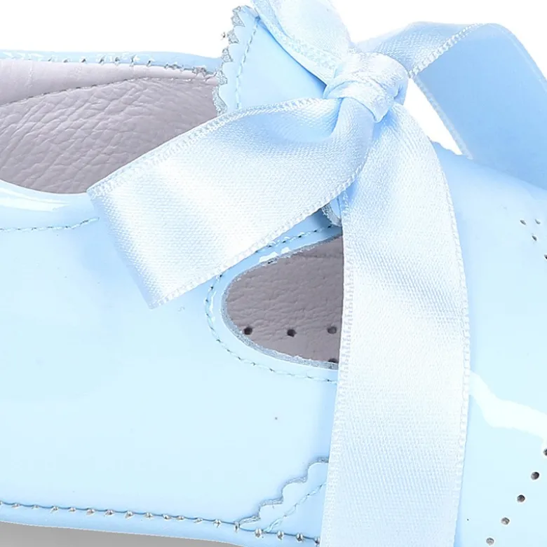 Angelito para bebés con lengüeta y lazo en piel charol.