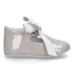 Angelito para bebés con lengüeta y lazo en piel charol.