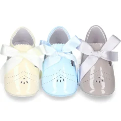 Angelito para bebés con lengüeta y lazo en piel charol.