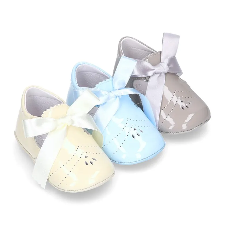 Angelito para bebés con lengüeta y lazo en piel charol.