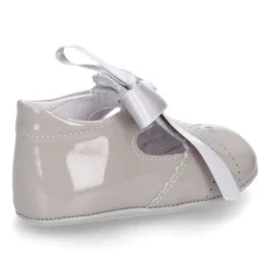 Angelito para bebés con lengüeta y lazo en piel charol.