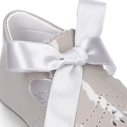 Angelito para bebés con lengüeta y lazo en piel charol.