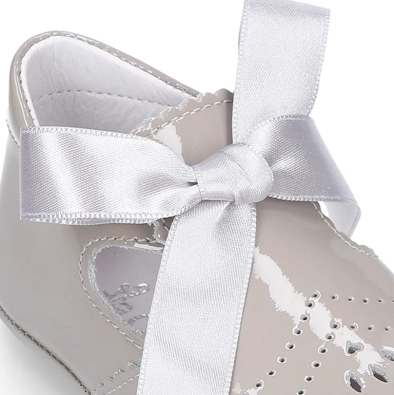 Angelito para bebés con lengüeta y lazo en piel charol.
