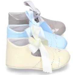 Angelito para bebés con lengüeta y lazo en piel charol.