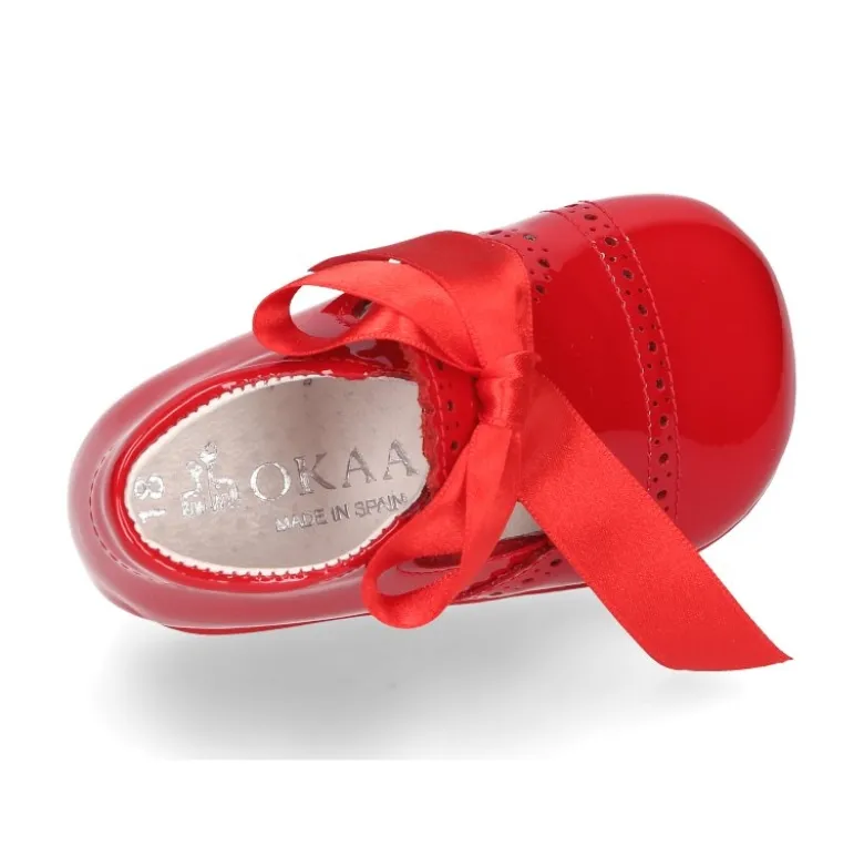 Angelito para bebés con lengüeta y lazo en piel charol.