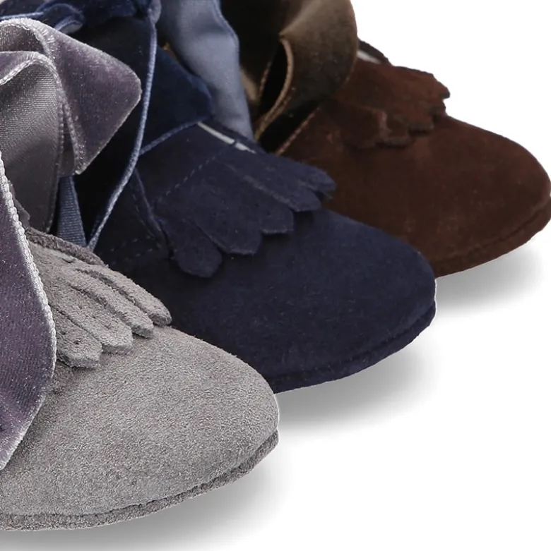 Botita bebé en piel serraje con flecos y lazo de terciopelo.