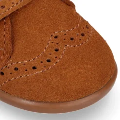 Botita clásica niños sin cordones tipo Blucher en piel serraje con picados y cuello de borreguito.
