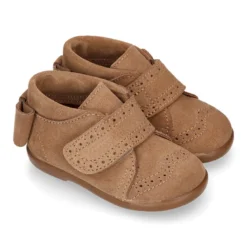 Botita niña sin cordones con lazo y picados en piel serraje.