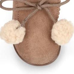 Botita niños con pompones y cuello borreguito en piel serraje.