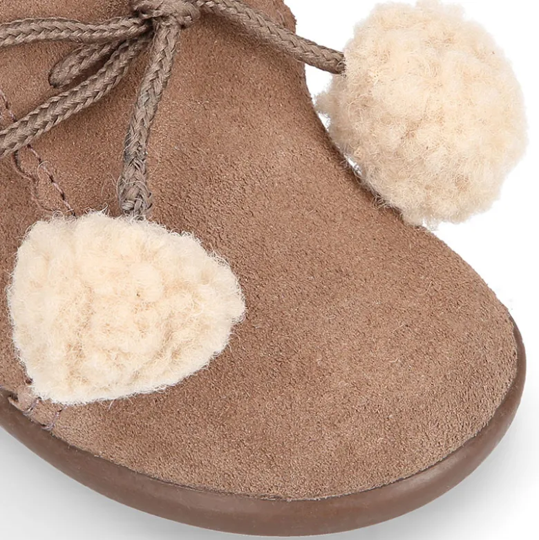 Botita niños con pompones y cuello borreguito en piel serraje.