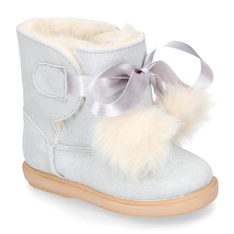 Botitas tipo Australianas niña con diseño con POMPONES en piel serraje metalizado.