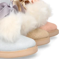 Botitas tipo Australianas niña con diseño con POMPONES en piel serraje metalizado.