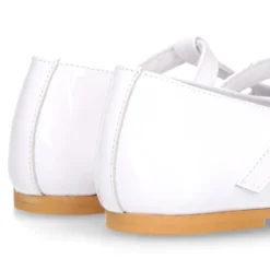 Mercedita niña Okaa en forma de T con picados en piel charol en color blanco.