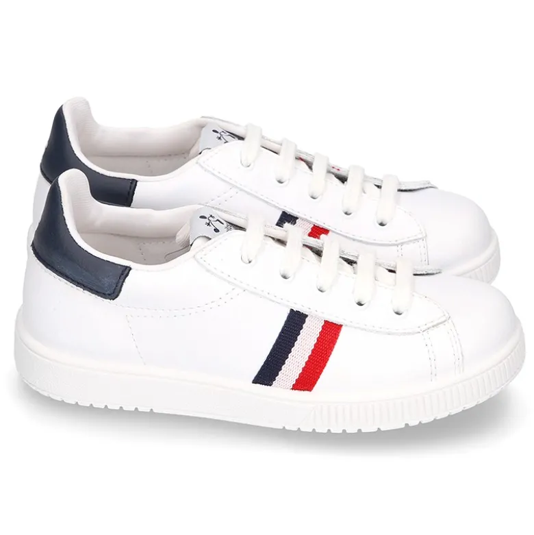 Zapatilla niño casual con cordones y bandera en piel lavable.
