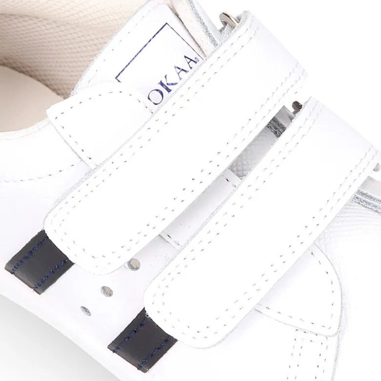 Zapatilla niños colegial OKAA sin cordones, rayas laterales y puntera reforzada en piel lavable.