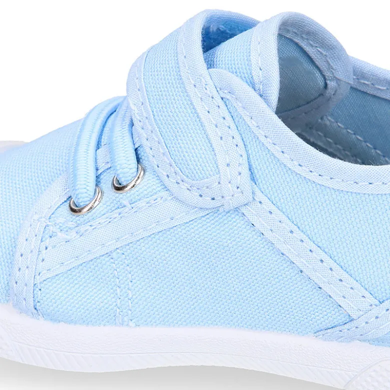 Zapatilla niños con puntera y cordones elásticos en lona en colores pastel.