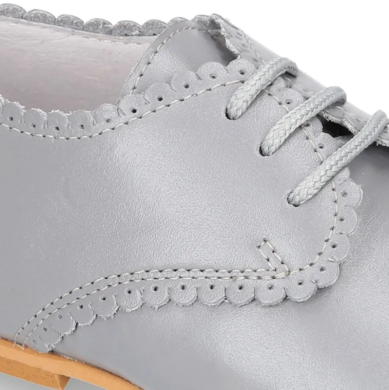 Zapatito clásico tipo BLUCHER con festón en piel napa.