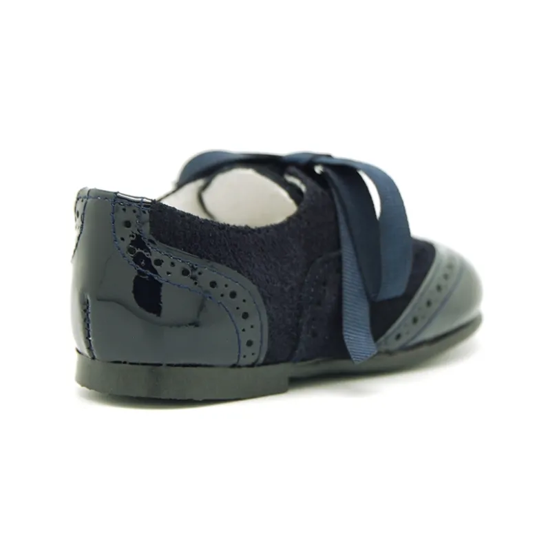 Zapatito tipo Blucher con lazos y picados en piel serraje con charol.