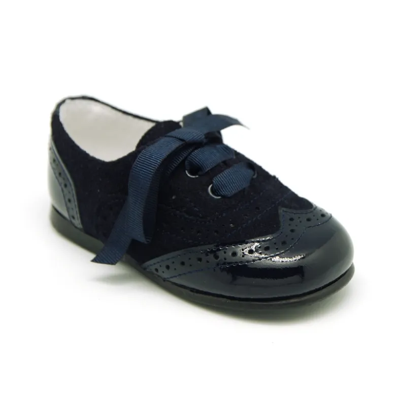Zapatito tipo Blucher con lazos y picados en piel serraje con charol.