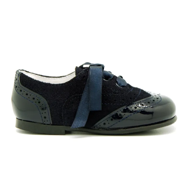 Zapatito tipo Blucher con lazos y picados en piel serraje con charol.
