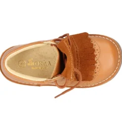 Zapatito tipo blucher con lengüeta con flecos y picados en piel combinada.