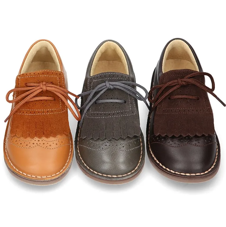 Zapatito tipo blucher con lengüeta con flecos y picados en piel combinada.