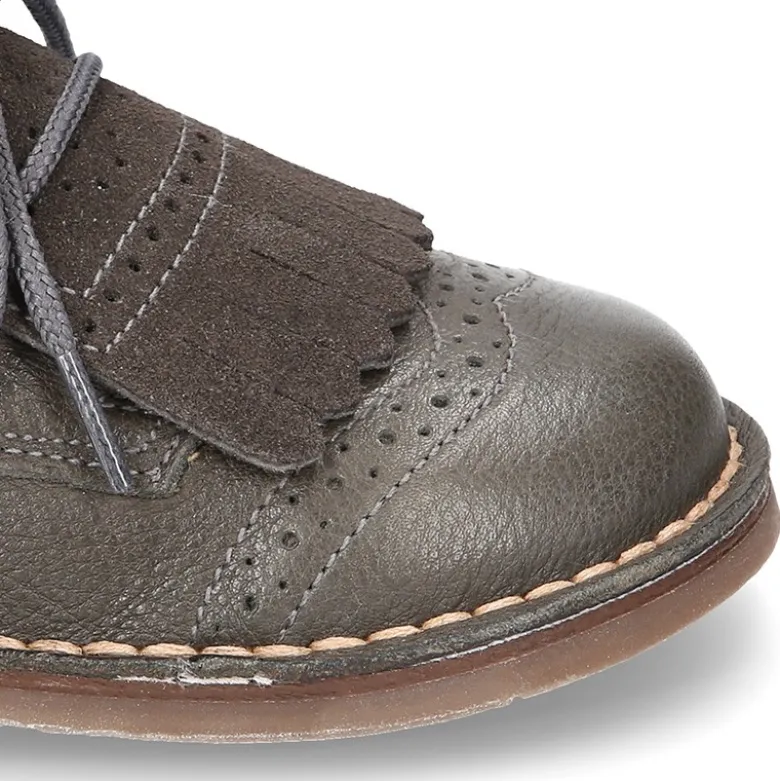 Zapatito tipo blucher con lengüeta con flecos y picados en piel combinada.