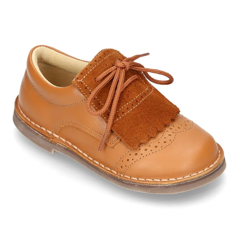 Zapatito tipo blucher con lengüeta con flecos y picados en piel combinada.