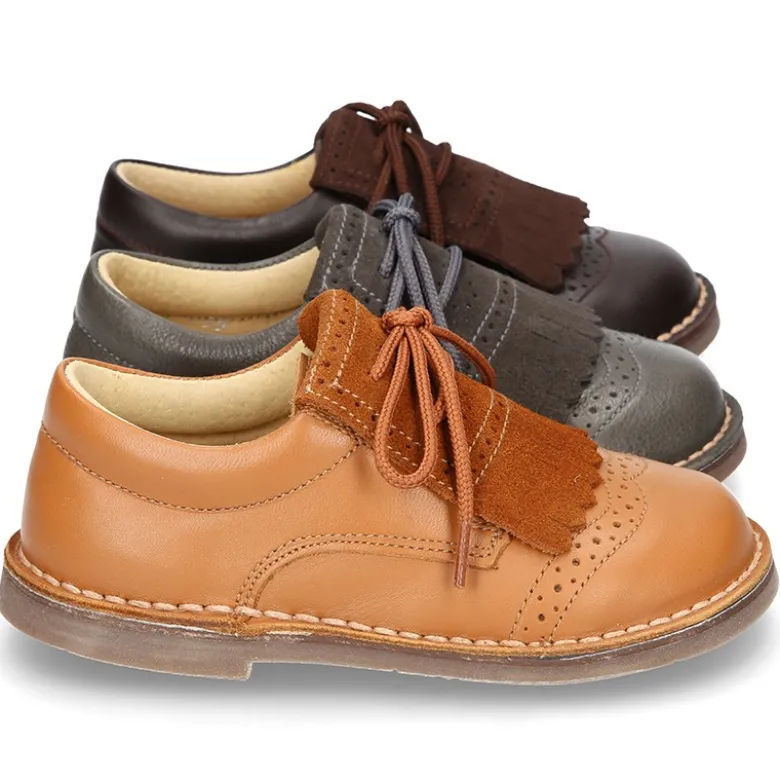 Zapatito tipo blucher con lengüeta con flecos y picados en piel combinada.