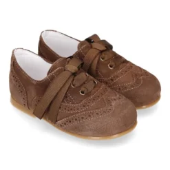 Zapatito tipo Blucher niño con lazo y picados en serraje.