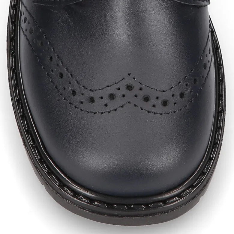 Zapato colegial niño tipo Blucher sin cordones y diseño pala vega en piel.