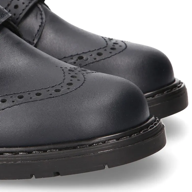 Zapato colegial niño tipo Blucher sin cordones y diseño pala vega en piel.