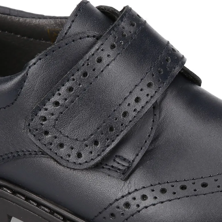 Zapato colegial niño tipo Blucher sin cordones y diseño pala vega en piel.
