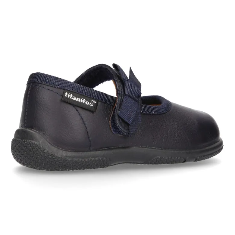 Zapato colegial tipo Mercedita con cierre adherente con lazo en piel lavable para niñas pequeñas.